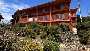 A two-story building with balconies, surrounded by dense shrubbery. - Carquinez Inn Vallejo I 80 Near Napa Valley (Vallejo)