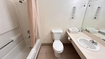 A bathroom with a toilet, sink, and shower.