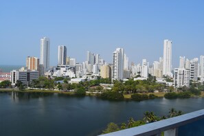 A cityscape with high-rise buildings, a body of water, and greenery.