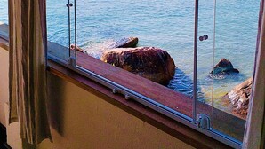Una habitación con un ventanal grande que da a una masa de agua tranquila con varios barcos.