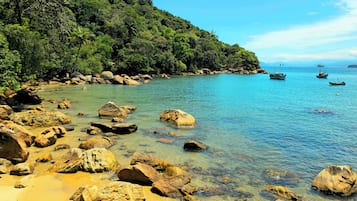 Un paisaje costero con aguas claras, rocas y barcos.