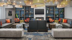 Un salon moderne avec des canapés, des poufs et une cheminée.