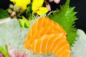 Lachs auf Eis mit einer grünen Blattanordnung.