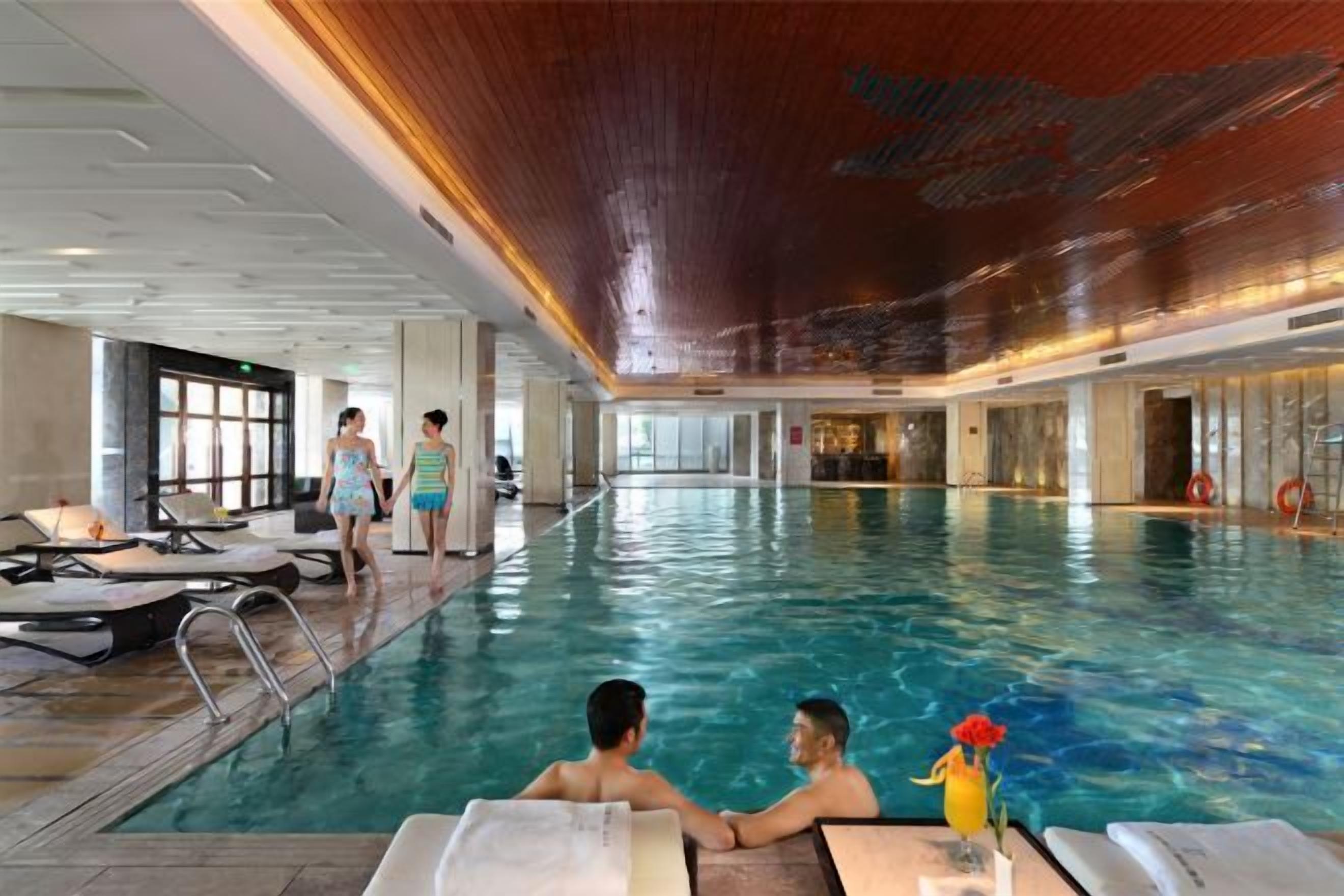 Una piscina interior amb gandules i una persona de peu a la piscina.