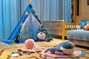 A child's play area with a tent, plush toys, and a bed.