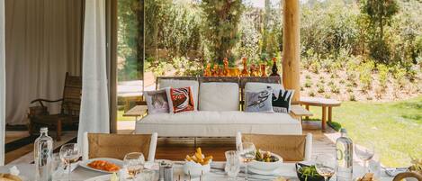 Comedor con mesa lista para una comida, con vistas a un jardín.