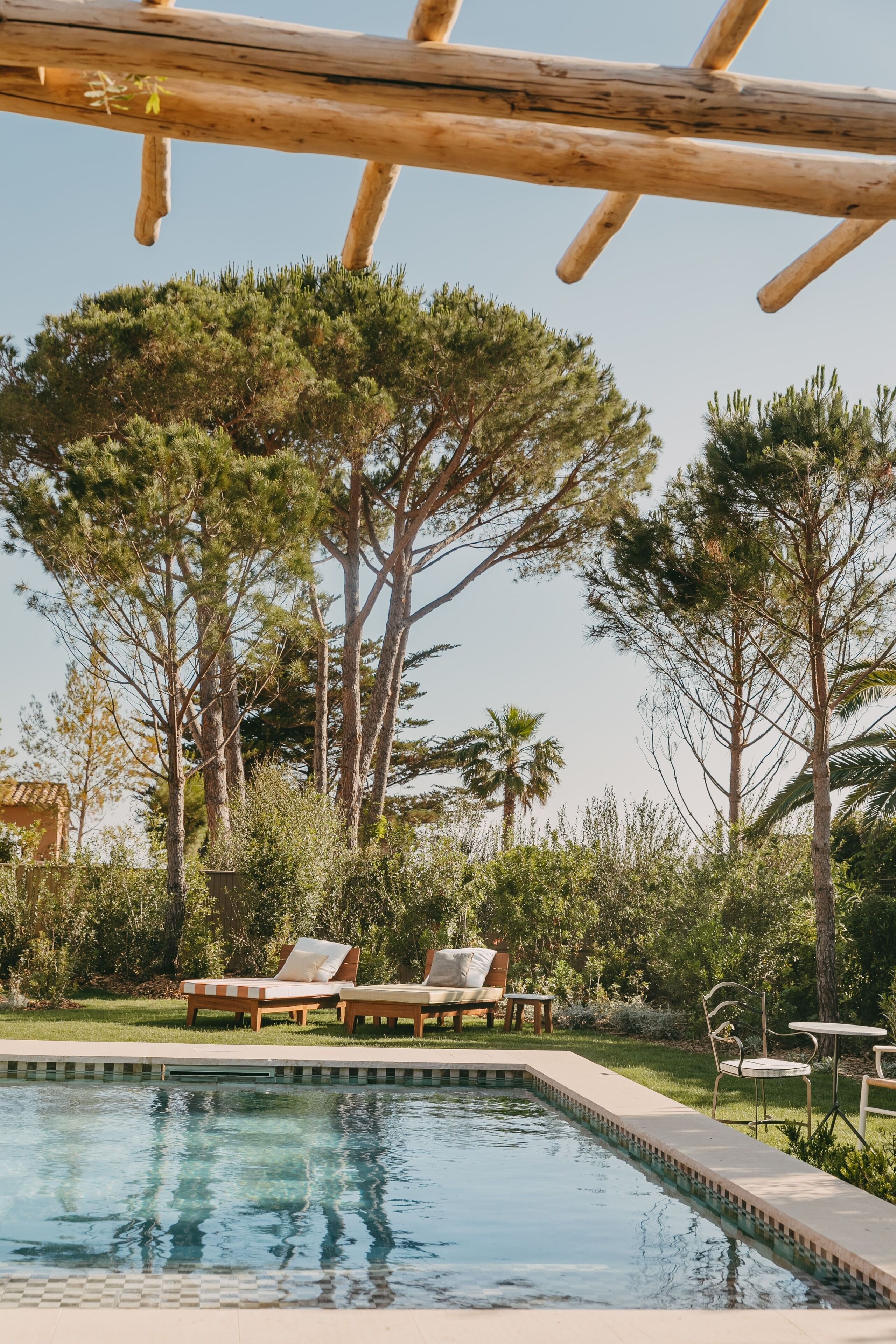 Ein Poolbereich mit Liegestühlen und einer Holzpergola.