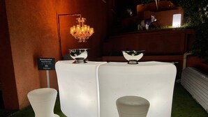 A round table with two white bowls on top, surrounded by three white stools. - Villa Colina (Mandelieu-La-Napoule)