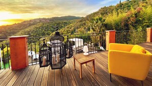 A wooden deck with outdoor furniture, a yellow chair, and birdcages. - Villa Colina (Mandelieu-La-Napoule)