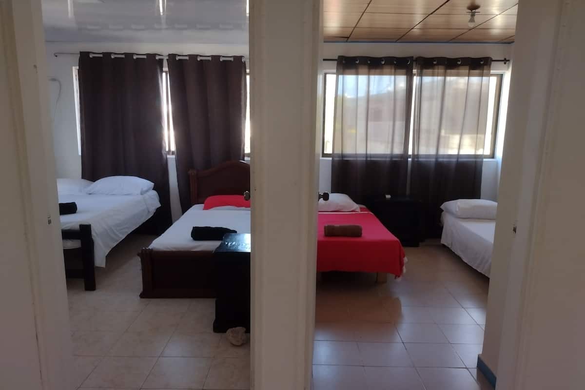 Una habitación con dos camas, un escritorio y una silla.