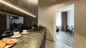 Eine moderne Küche mit Granitarbeitsplatte, Edelstahlgeräten und einem Essbereich mit Tisch und Stühlen.