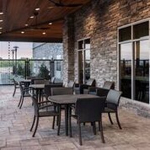 An outdoor patio area with stone flooring, tables, and chairs. - Holiday Inn Express & Suites Odessa I-20 by IHG (Odessa)