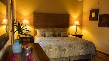 Un dormitorio con una cama grande, dos mesitas de noche, un florero y un espejo.