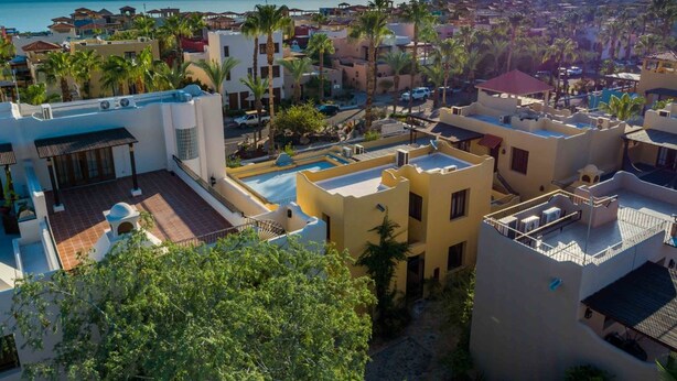 A coastal residential area with modern buildings, a swimming pool, and palm trees. - Casa Colette FN 307 2 BR by Casago (Loreto)