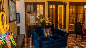 A room with a blue sofa, a table with a vase of flowers, and a painting on the wall. - Casa Colette FN 307 2 BR by Casago (Loreto)