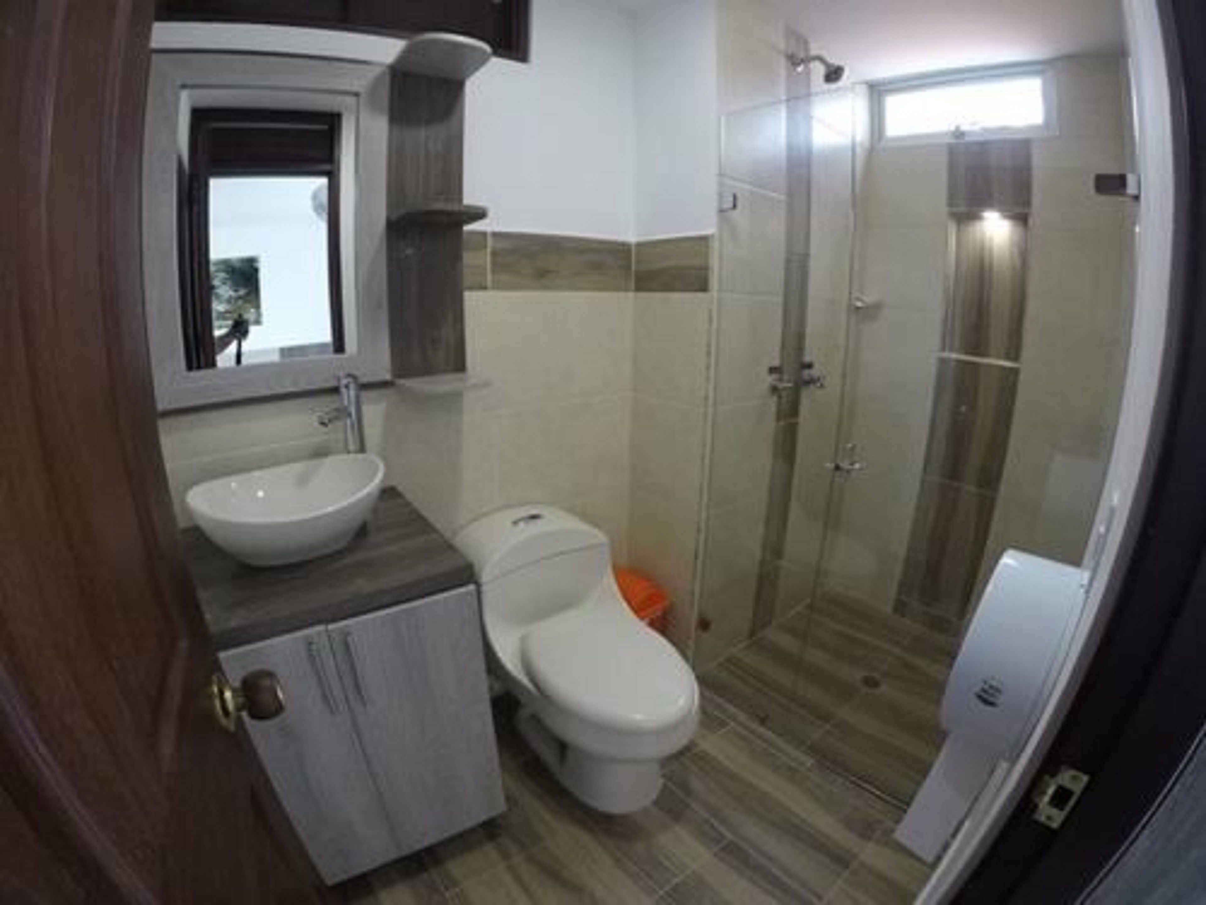 A bathroom with a toilet, sink, and shower.