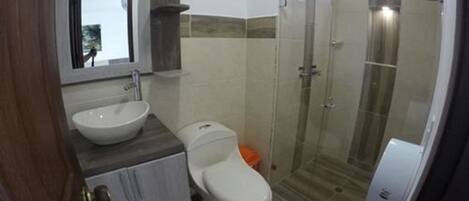A bathroom with a toilet, sink, and shower.