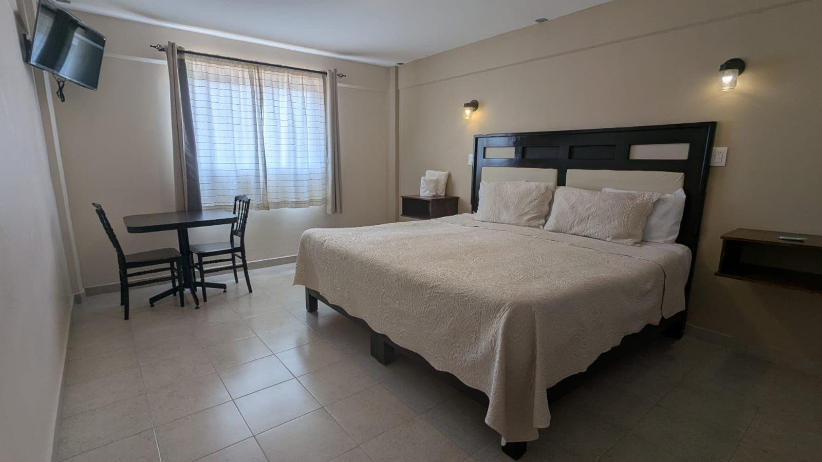 A bedroom with a bed, a desk, and a chair.
