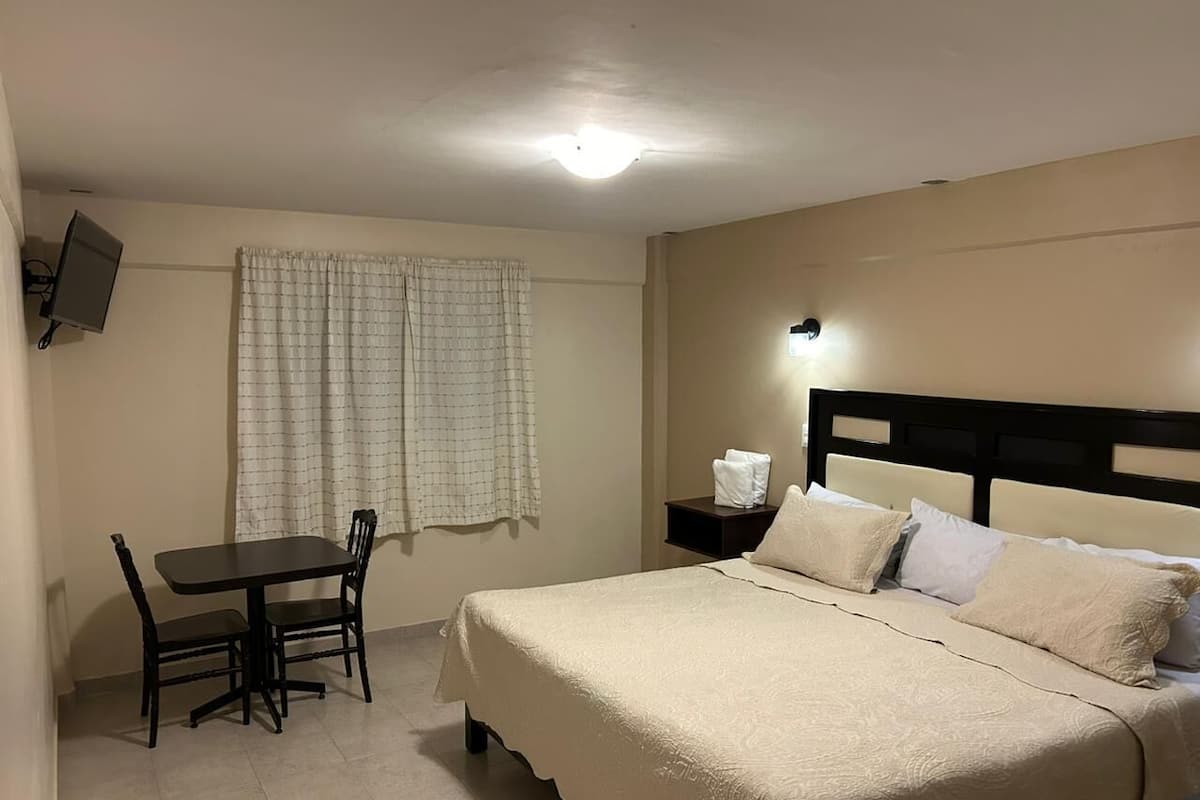 Una habitación de hotel con una cama, un escritorio y una silla.