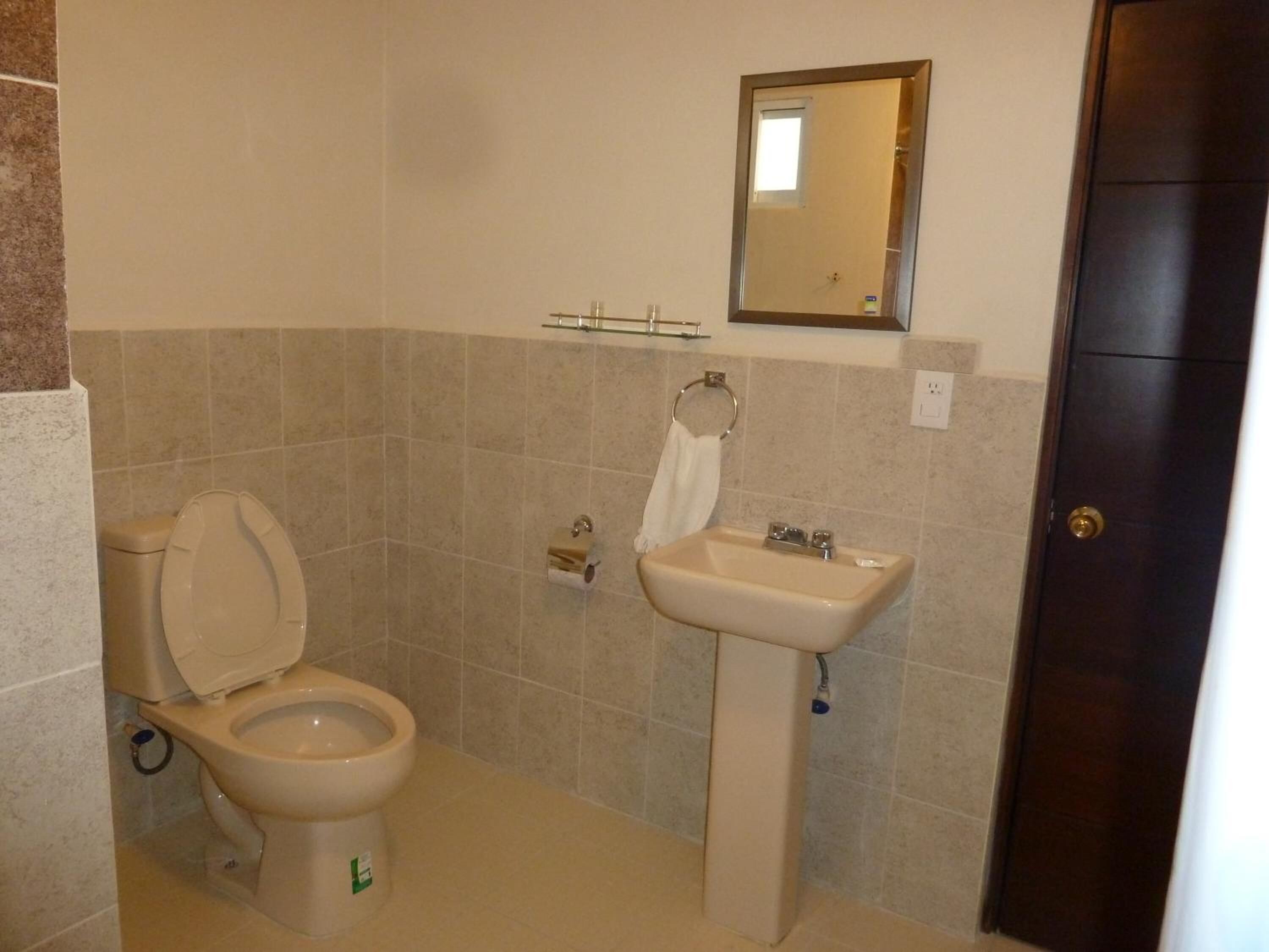 Ein Badezimmer mit Toilette, Waschbecken und Spiegel.