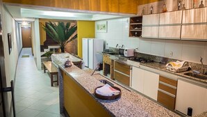 Eine Küche mit Granit Arbeitsplatte, weißen Schränken und einer kleinen Kochinsel.