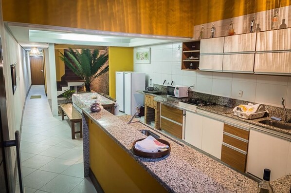 A kitchen with a granite countertop, white cabinets, and a small island.