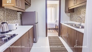 A modern kitchen with wooden cabinets, a stainless steel refrigerator, and a coffee maker.