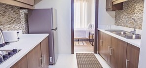 Una cocina moderna con armarios de madera, un refrigerador de acero inoxidable y una cafetera.