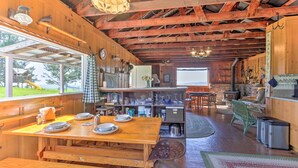 A rustic wooden interior with a dining area, kitchen, and large windows overlooking a yard. - 'Moonview Ranch' on 20 Acres in Sonoma County! (Sebastopol)