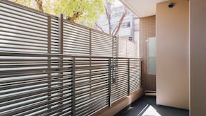 Un intérieur moderne avec un séparateur en métal, une petite fenêtre et un mur recouvert de carreaux.
