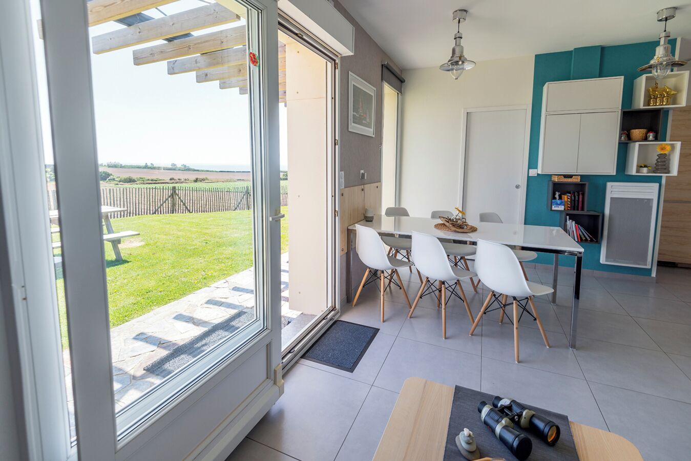 A modern kitchen with a dining area, a large window, and a view of the outdoors.