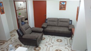 A living room with two sofas, a small table, and a tiled floor. - Filfor Hause (Cusco)