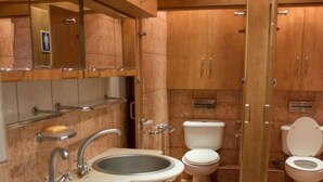 Un baño con dos lavamanos, un inodoro y un bidé.