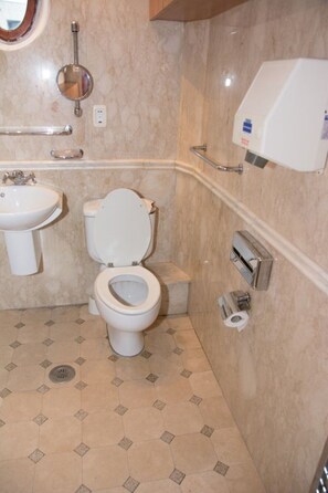 A bathroom with a toilet, sink, and hand dryer. - Apartments Faryna is situated in the real heart of Bucharest  (Sector 1)