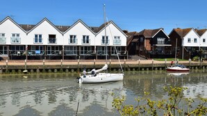 A row of white houses with a canal in the foreground. - ‘Waterside’ is a 1st floor apartment  on the river in Rye, East Sussex (Rye, East Sussex)