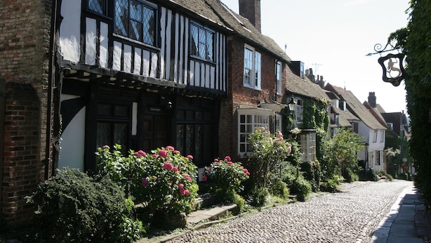 A traditional half-timbered building with a cobblestone street, surrounded by lush greenery and flowering plants. - ‘Waterside’ is a 1st floor apartment  on the river in Rye, East Sussex (Rye, East Sussex)