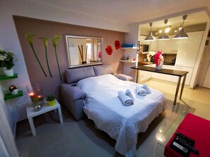 Een moderne hotelkamer met een bed, nachtkastje en een tafeltje met een bloevas.