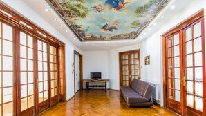 A spacious room with wooden floors, a sofa, a television, and a ceiling mural. - Unique apartment situated in the real heart of Bucharest  (Sector 1)