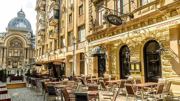 A café with outdoor seating, a historic building in the background, and a sign reading "NEGRESCO". - Unique apartment situated in the real heart of Bucharest  (Sector 1)