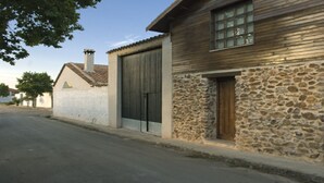 Un edificio con facciata in pietra e un'ampia porta in legno.