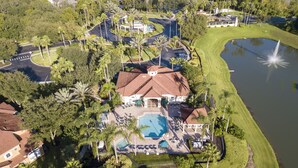 Vista aérea de um resort com piscina, quadra de tênis e campo de golfe.