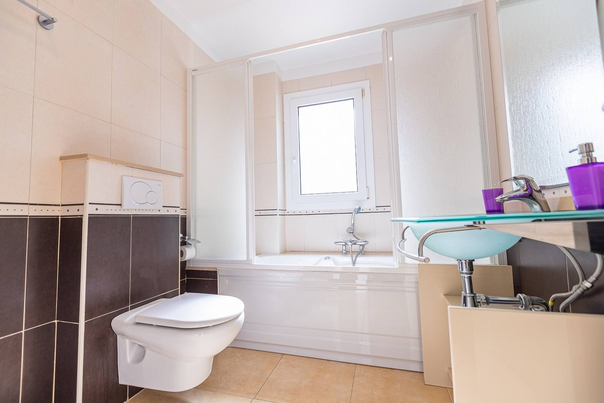 A bathroom with a toilet, a bathtub, and a sink.