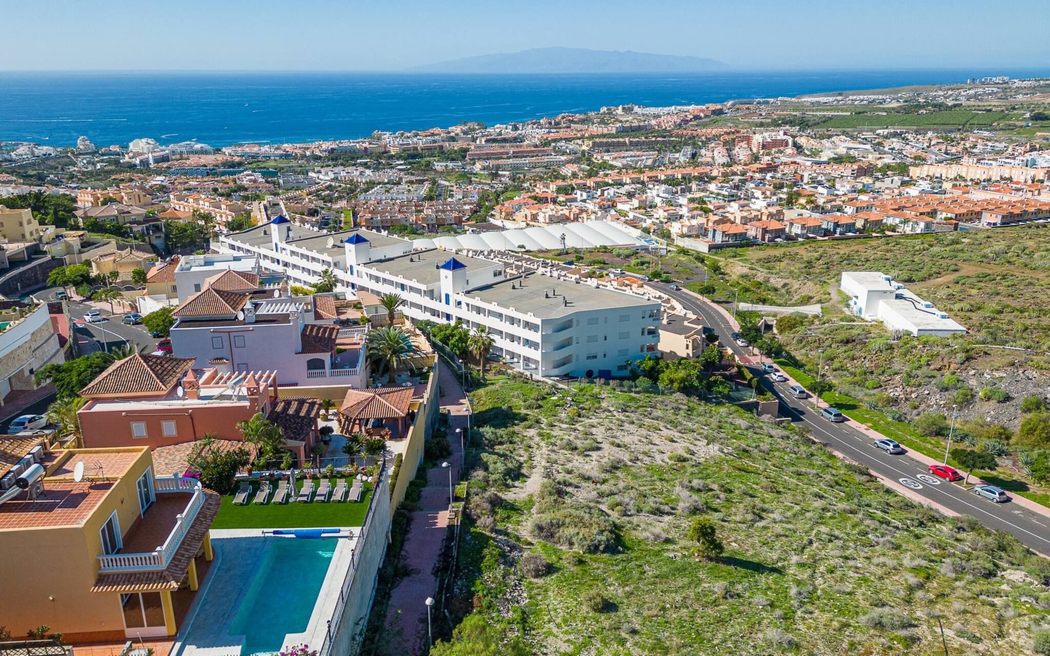 Un hôtel situé sur la côte, doté d’une piscine, d’un parking et offrant une vue sur la mer et le paysage urbain.