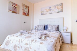 A bedroom with a large bed, two bedside tables, and artwork on the walls. - Villa with private pool and magnificent views of Nekhamkin (Costa Adeje)
