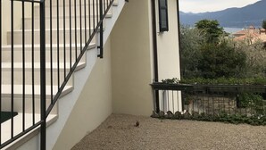 Eine Treppe mit schwarzen Geländern führt zu einem Gebäude mit einer beigen Fassade.