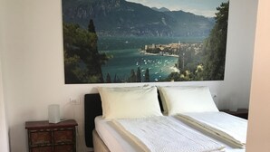 Ein Schlafzimmer mit einem großen Bett, einem kleinen Nachttisch und einem Sessel.
