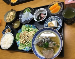 Una bandeja con diferentes platos, incluyendo arroz, sopa y verduras.