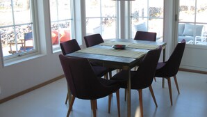 En matplats med ett bord och stolar, stora fönster och utsikt över omgivningen.