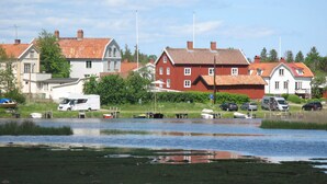 En vy över en sjö med hus, båtar och en husbil.