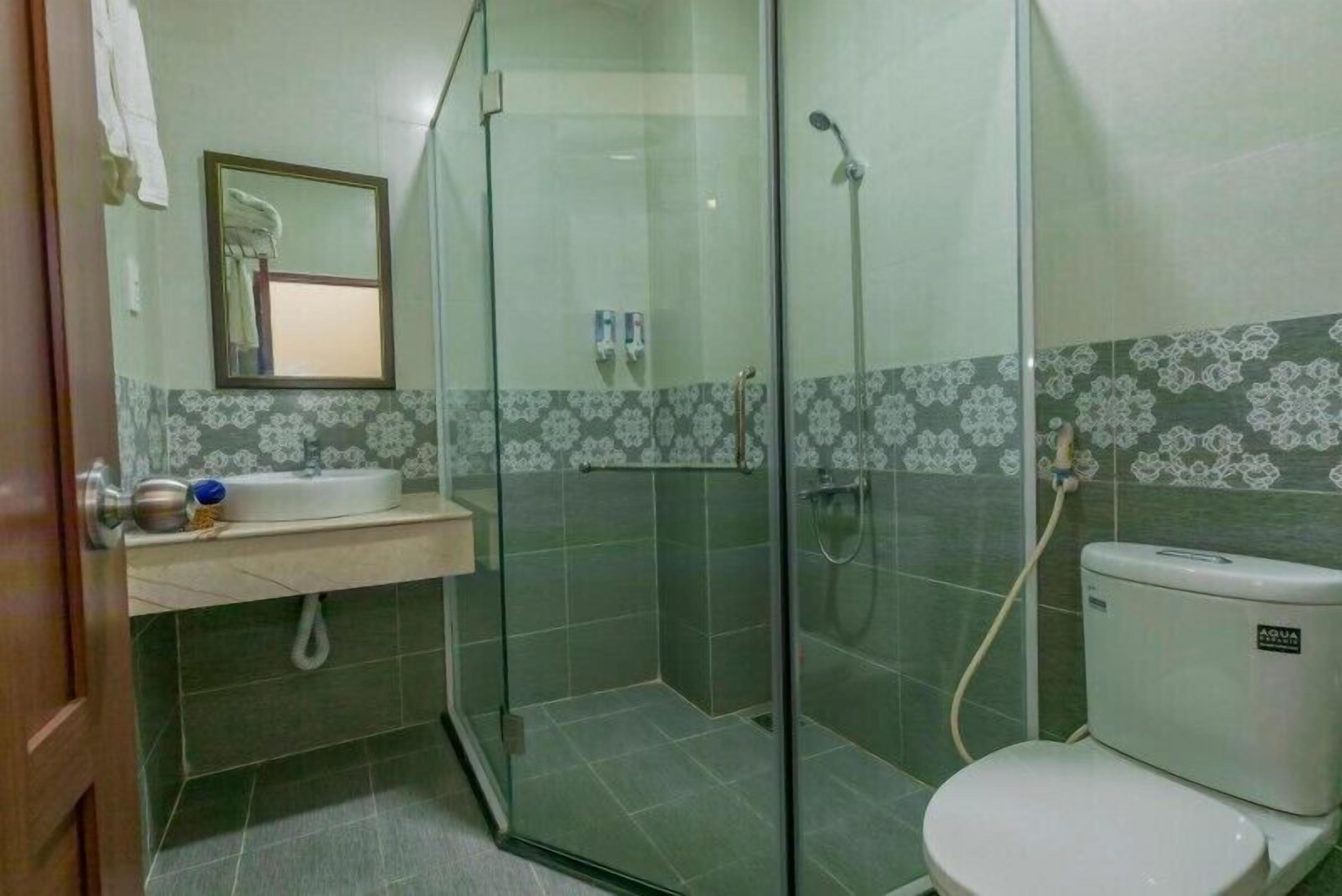 Un baño con ducha de vidrio, lavamanos e inodoro.